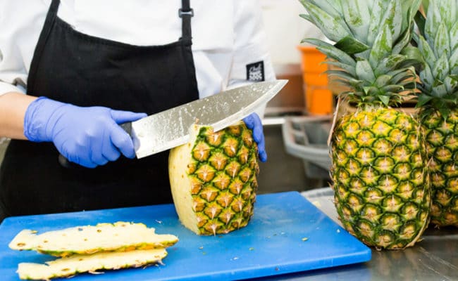 caterer cutting pineapples